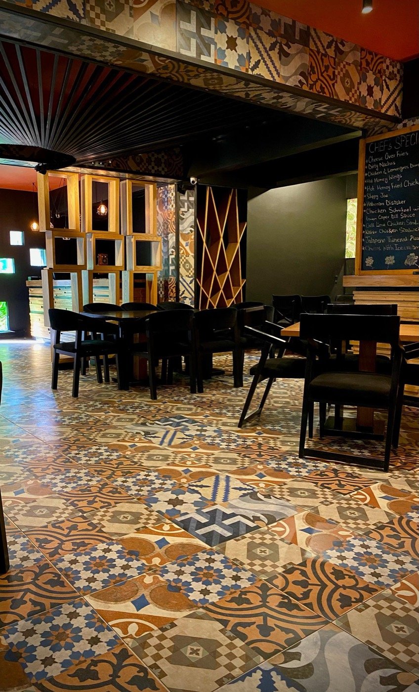 Sobremesa's dining room with patterned floor tiles, wooden tables and warm lighting